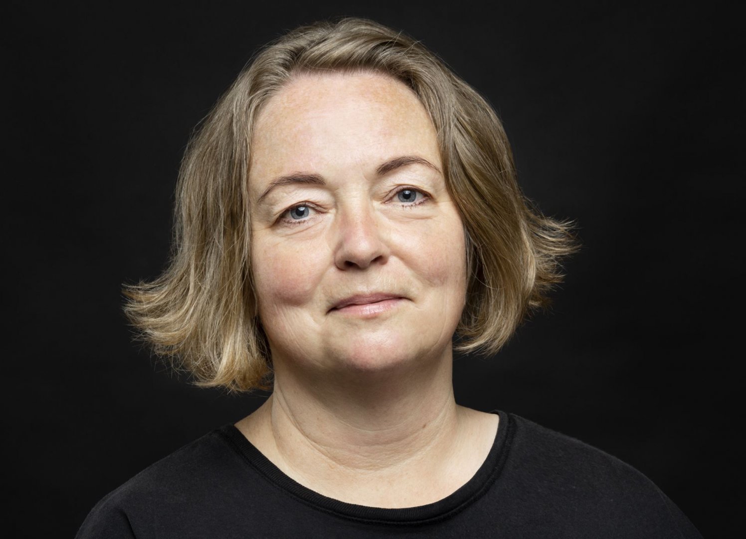 Portrait einer lächelnden Frau mit brauenen Haaren bis zum Kinn