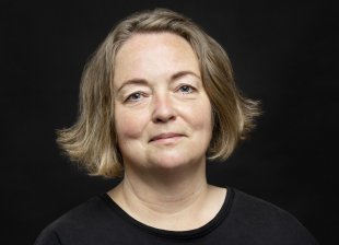 Portrait einer lächelnden Frau mit brauenen Haaren bis zum Kinn