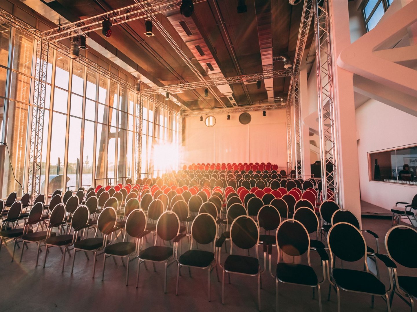 Sonne strahlt in den bestuhlten Saal 