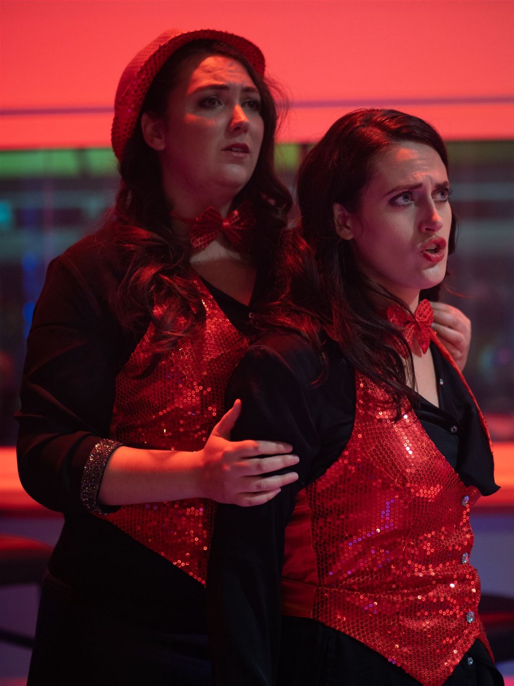 Flora steht hinter Violetta, beide singen