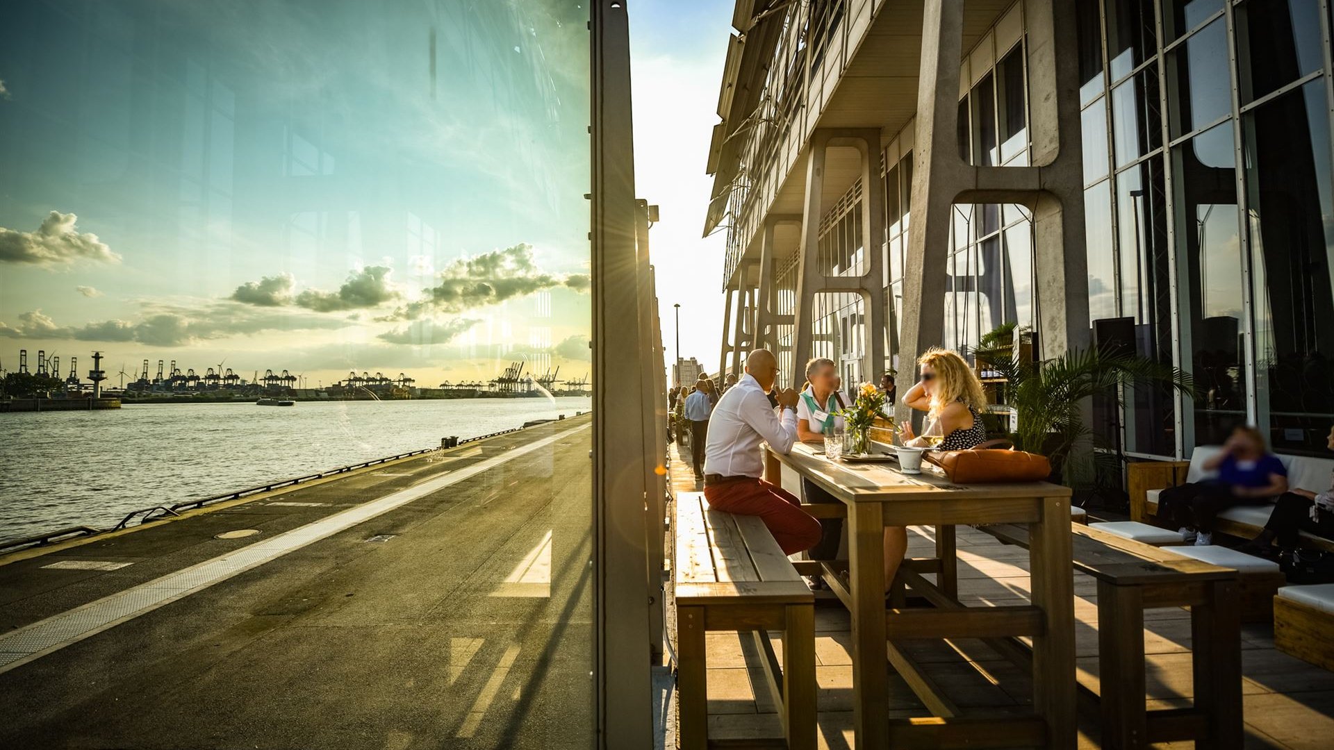 Gäste sitzen an Tischen auf der Terrasse mit Elbblick